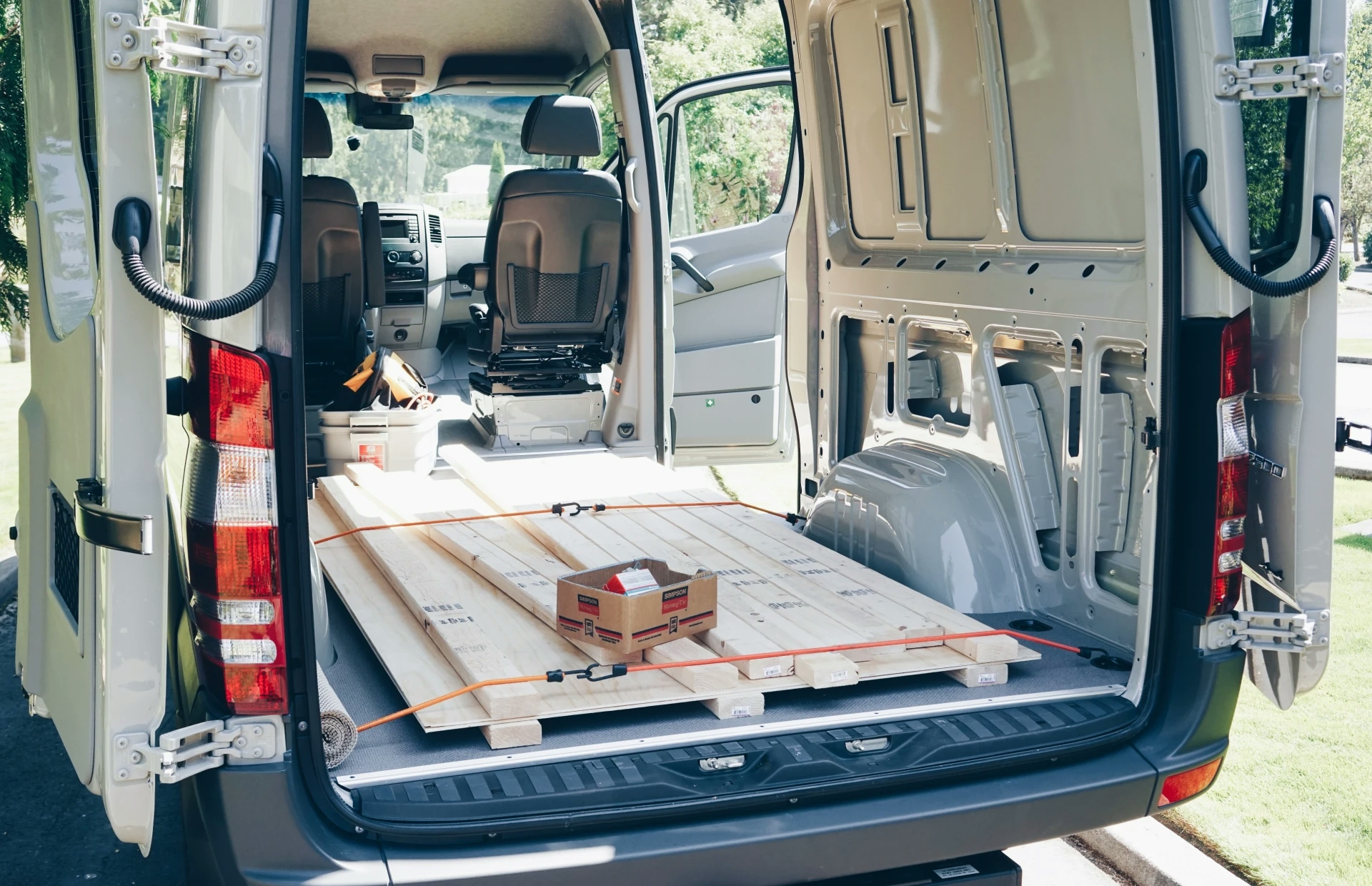 image showing the interior of the empty van with two by fours and plywood fresh from the hardware store