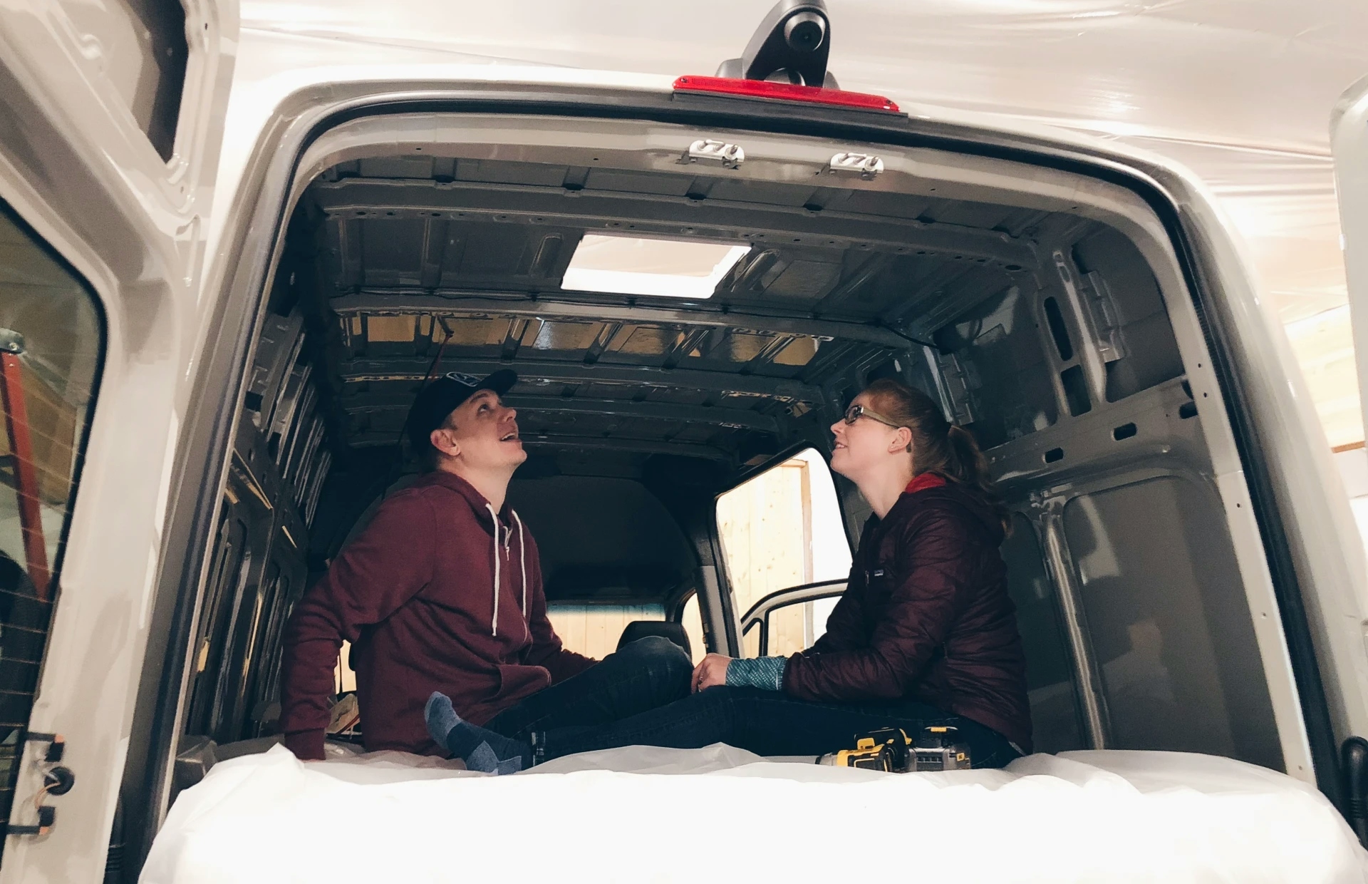 image of tucker and hattie looking at the hole they just put in the roof of their new van