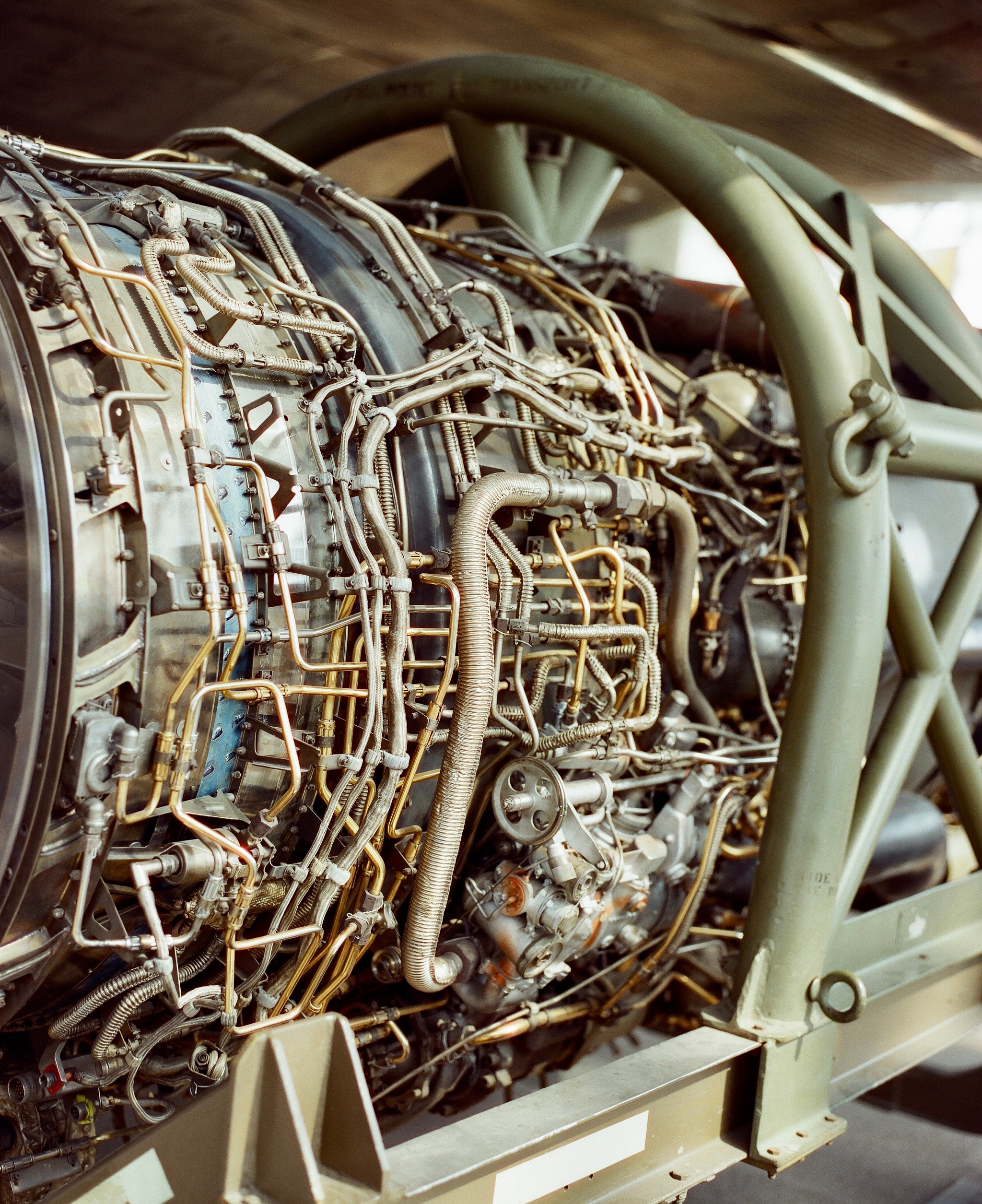 SR-71 engine without cowling, golden pipes and tubes bent at angles.