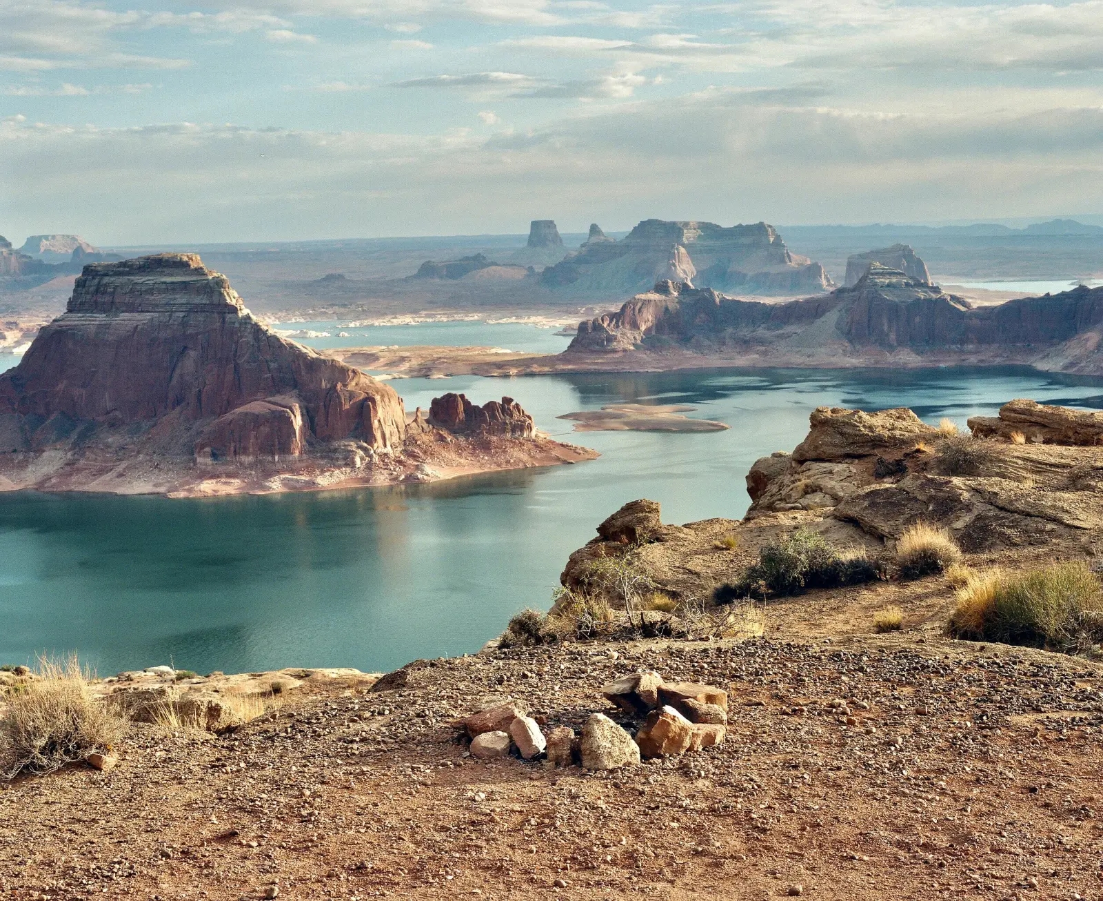 Lake Powell with low water level, surrounded by high gradient canyon cliffs, bright blue water, near sunset