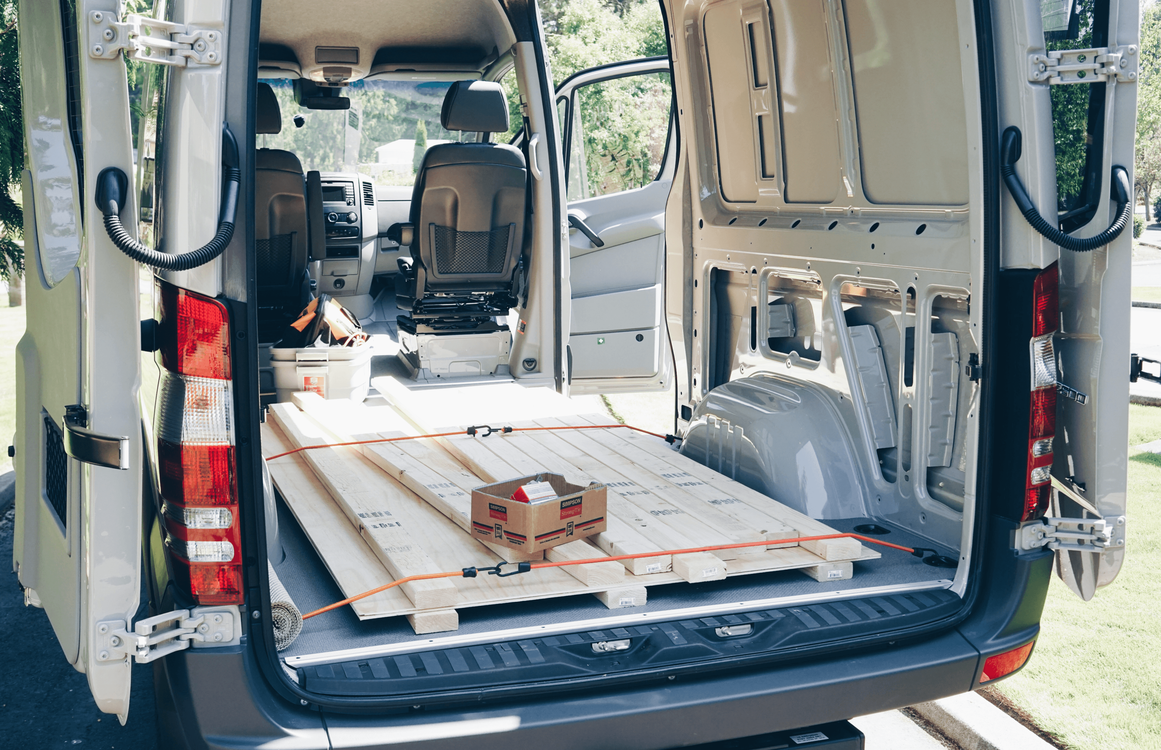 image showing the interior of the empty van with two by fours and plywood fresh from the hardware store