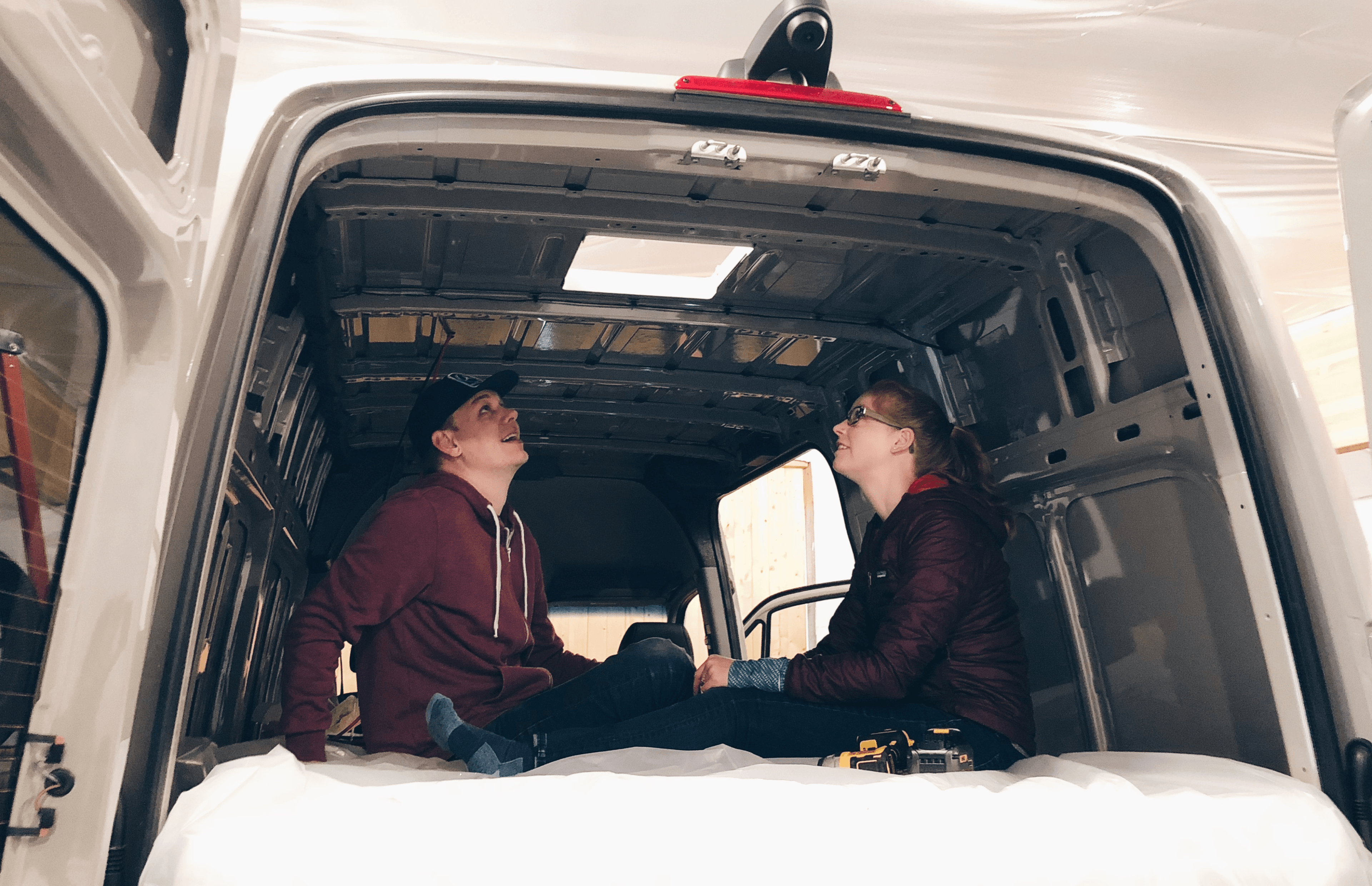 image of tucker and hattie looking at the hole they just put in the roof of their new van