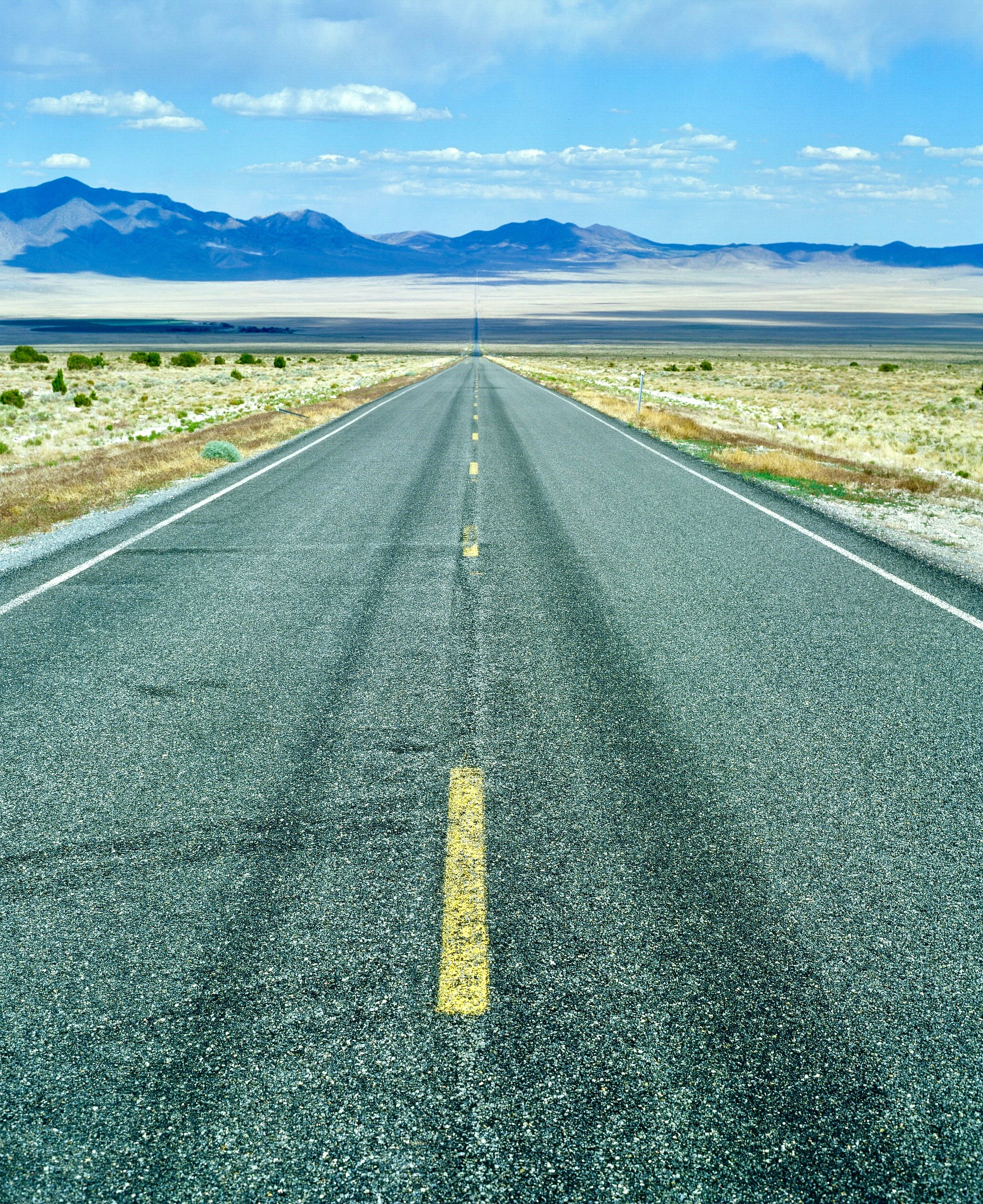 desert highway stretches into the distance across a great basin converging at an infinite vanishing point